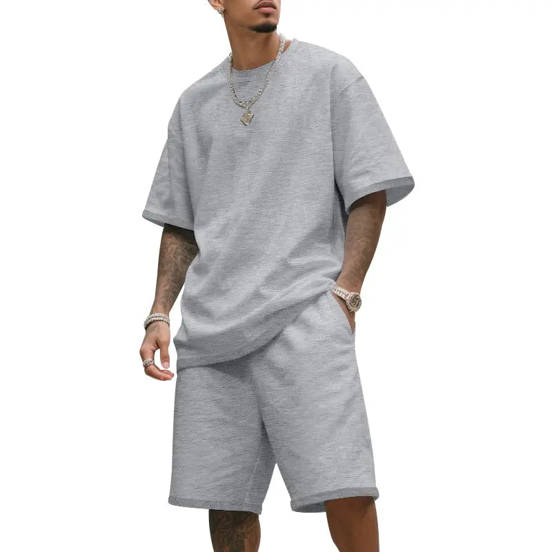 Conjunto veraniego de dos piezas para hombre compuesto por camiseta casual de algodón gris jaspeado y conjunto de pantalones cortos a juego.