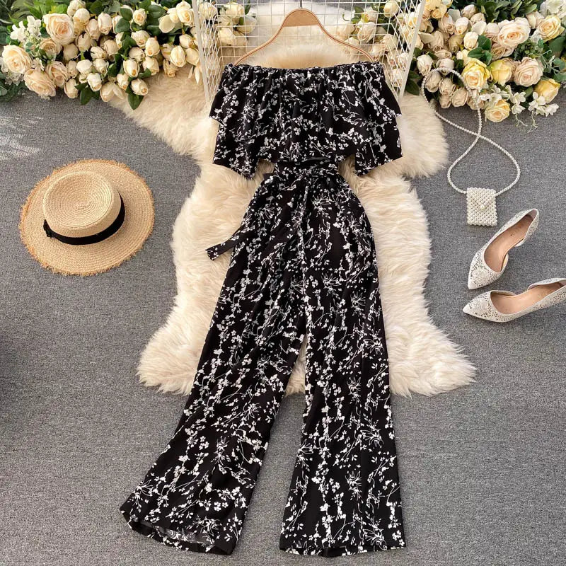 Enterizo de pierna ancha con estampado floral blanco y negro, con escote tipo bardot, mangas con volante y cinturilla con autoajuste.