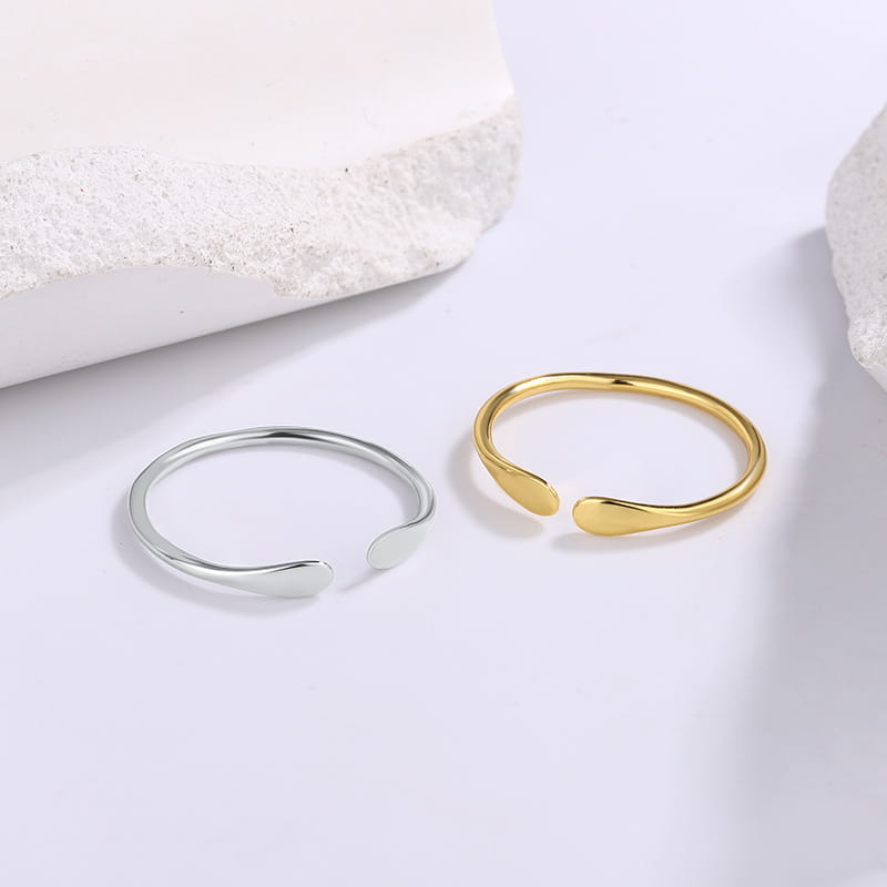 Anillos apilables abiertos con extremos lisos con forma de gota de diferentes tamaños, elaborados en plata de ley y oro.