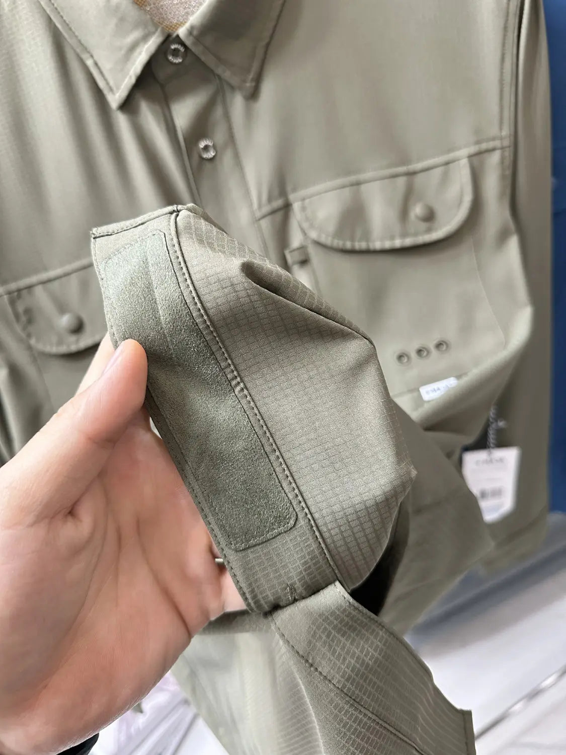 men’s tactical outdoor long sleeve shirt in olive green with a subtle grid texture and buttoned chest pockets.
