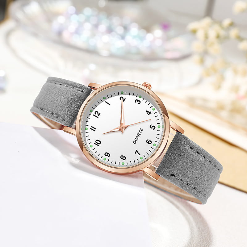 Rose gold women leather quartz watch featuring a delicate rose gold-toned case, white dial with green-accented hour markers, and a soft gray suede strap.