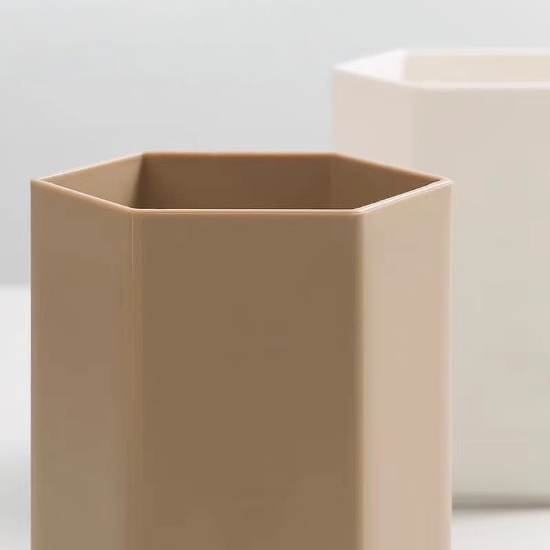 Porte-brosse à dents en plastique hexagonal beige conçu comme organisateur de bureau et porte-stylo.
