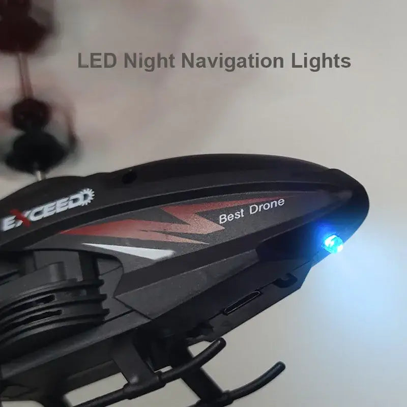 Black plastic remote control induction helicopter with red and white exceed branding and glowing blue led night navigation light designed for optimal flight time and efficient charging time.