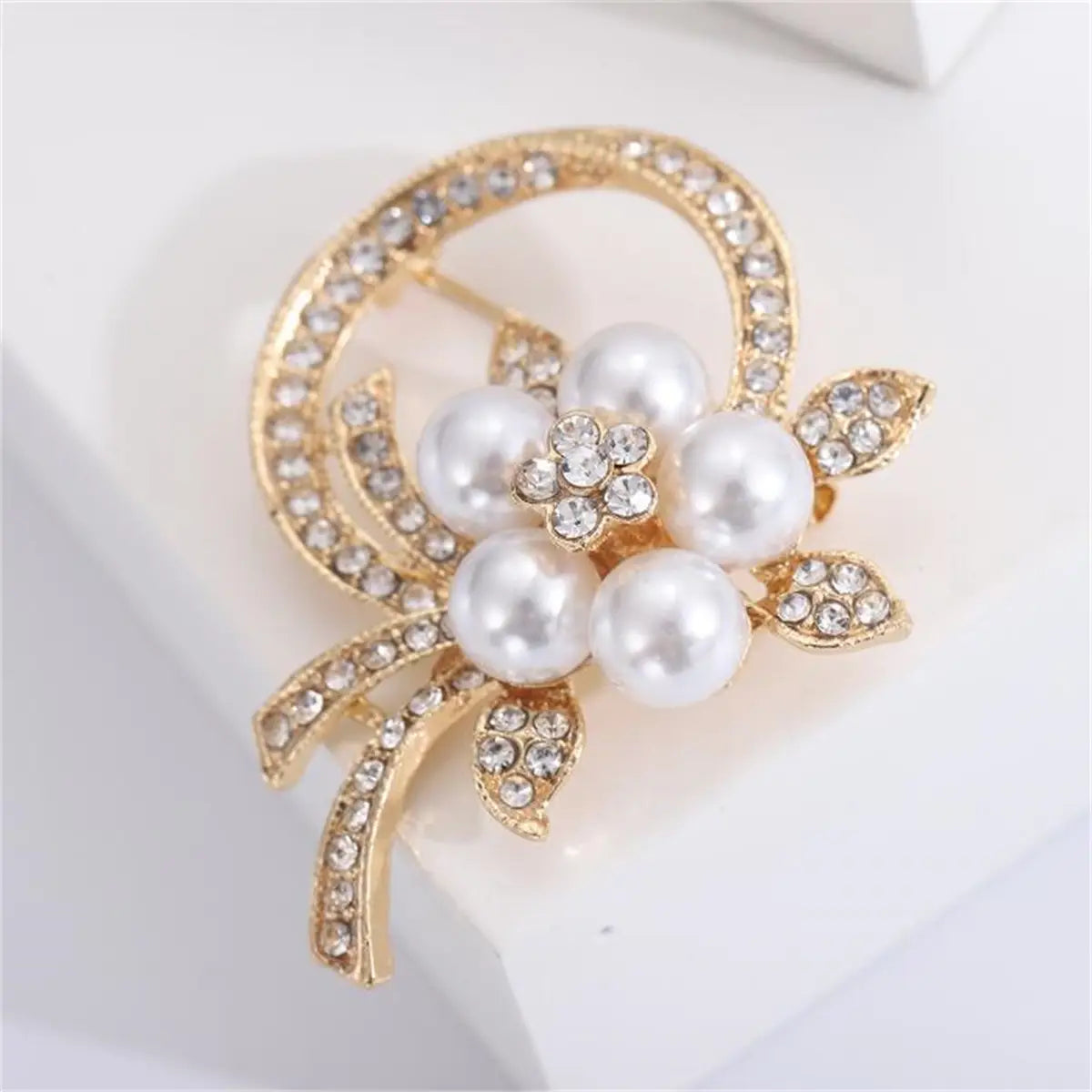 Broche floral con baño en tono dorado, adornado con perlas blancas y pedrería transparente, para alfiler de moda unisex de lujo.