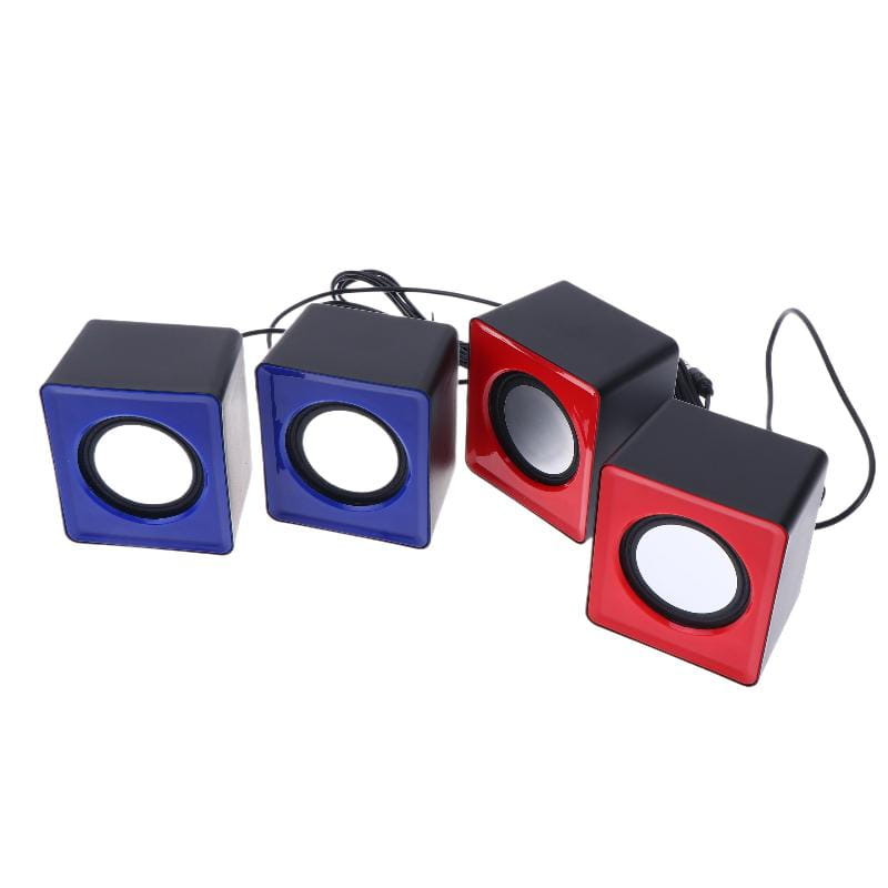 Ensemble de quatre mini haut-parleurs de bureau USB compacts en forme de cube, en bleu et rouge vibrants, avec des accents noirs, avec des boîtiers en plastique brillants pour l’audio stéréo sur ordinateur.