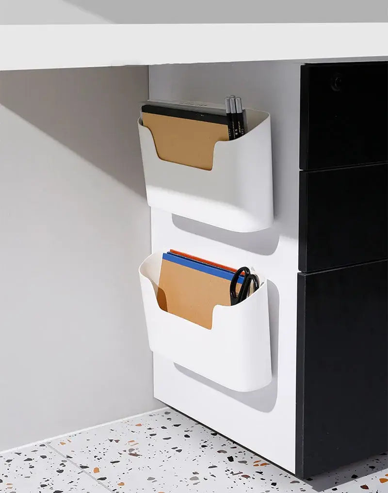 grille de rangement murale blanche en plastique, à deux compartiments, contenant des dossiers et des fournitures de bureau, mettant en valeur la caractéristique d’organisateur d’évier mural à fixation adhésive.