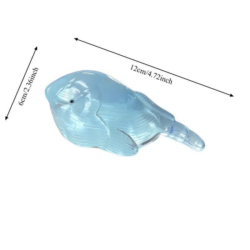 une statuette de baleine en verre translucide bleu clair, avec des reliefs détaillés et un petit œil noir, provenant du coffret de jouets anti-stress à mâcher « baleine » en matériau souple