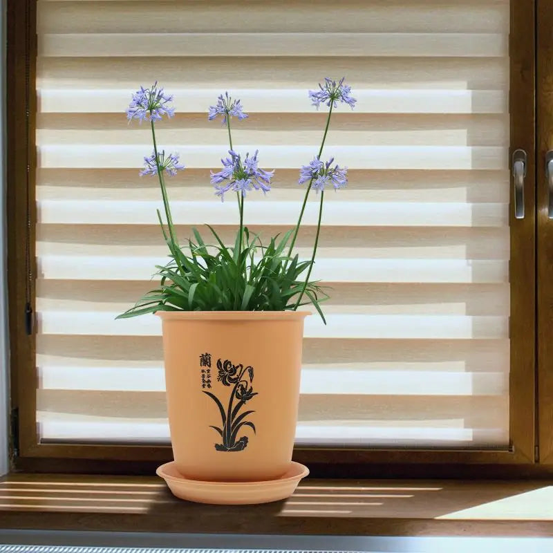 黒い花柄のデザインと、マッチする受け皿を備えたベージュの陶器製ラン鉢。植物の育苗用鉢および苗用鉢として使用できます。