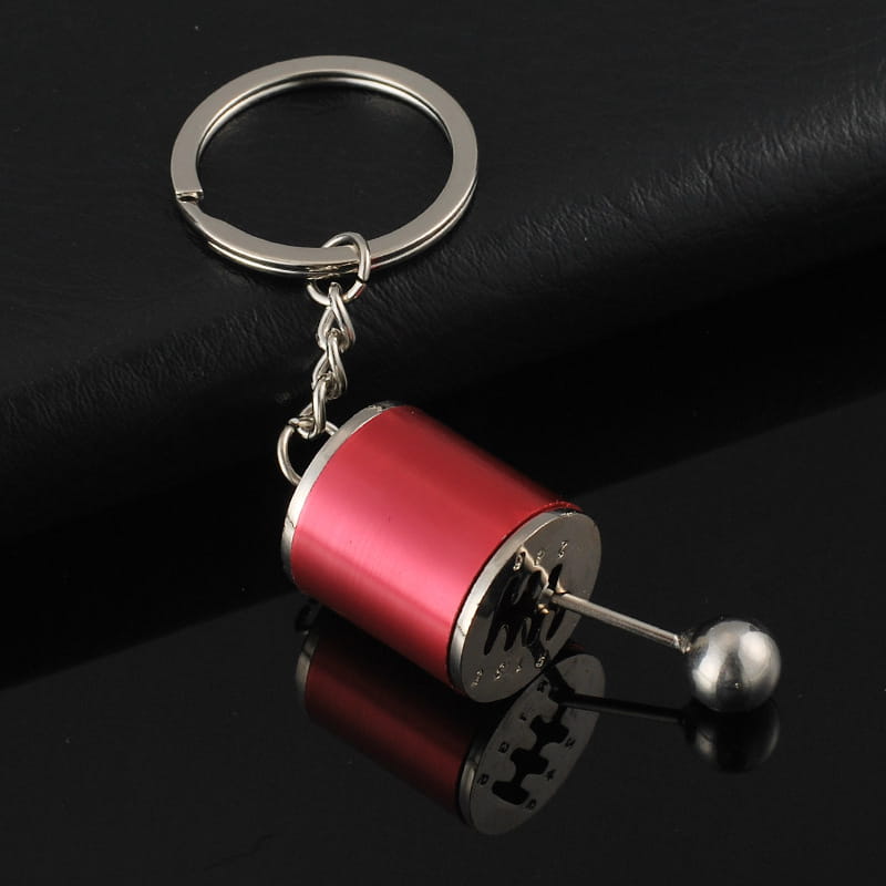Red and silver manual gear shift car keychain made of metal with a metallic ball knob.