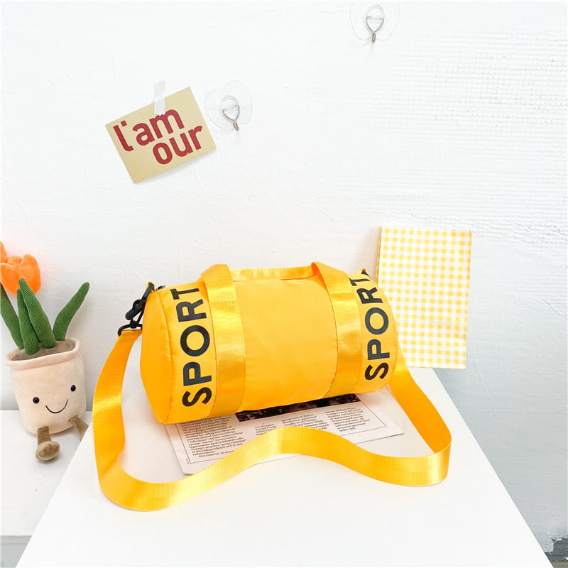 Leuchtend gelbe zylindrische Kinder-Sport-Reise-Sporttasche mit sportlicher Bedruckung in Schwarz entlang der Seiten und passendem Satin-Schulterriemen, entworfen für Reise-, Gym- und Crossbody-Gepäck.
