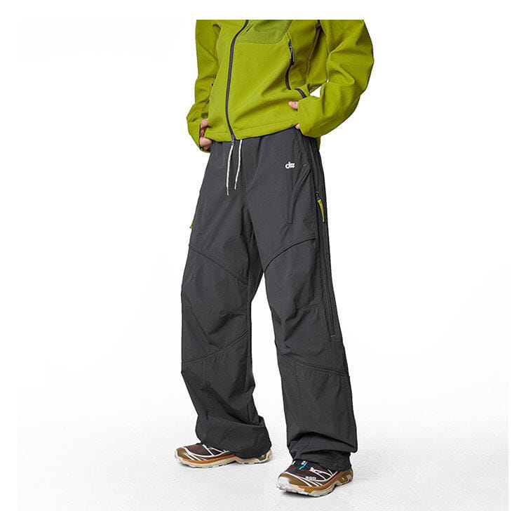 pantalones cargo impermeables de senderismo para hombre en gris oscuro, con tejido resistente, paneles reforzados y acentos sutiles de cremallera amarilla, diseñados para secado rápido y uso en exteriores.