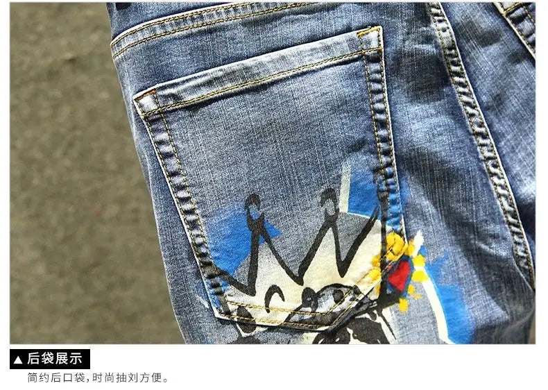 Jean slim imprimé stretch en denim bleu pour homme présenté de l’arrière, avec un graphisme de couronne vibrant de style graffiti sur la poche arrière