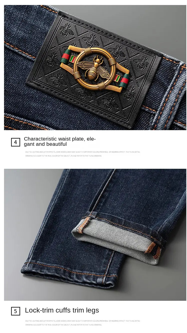 Slim fit dark blue denim jeans for men featuring a decorative black leather waist plate with an embossed bee emblem and gold toned metal accents.