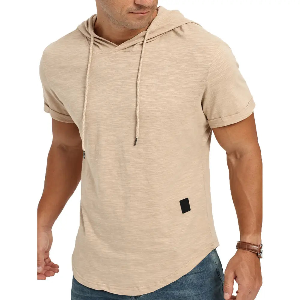 Veste à capuche légère et respirante beige à manches courtes avec capuche à cordon et écusson rectangulaire noir sur la partie inférieure avant, conçue pour des tenues décontractées.