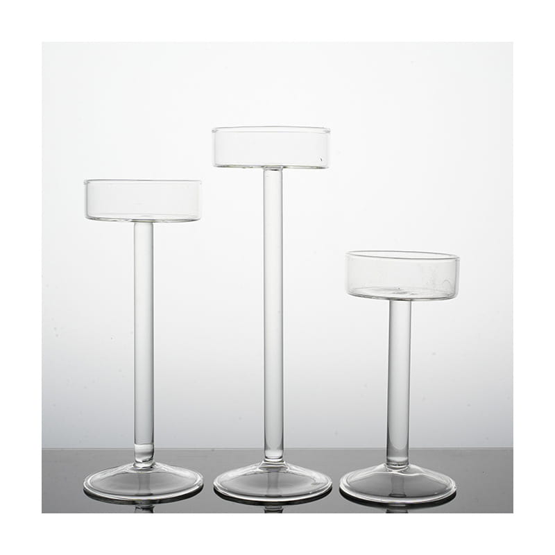 Juego de tres portavelas de pilar de vidrio transparente, con tallos esbeltos y bases circulares, para una decoración moderna de mesa.