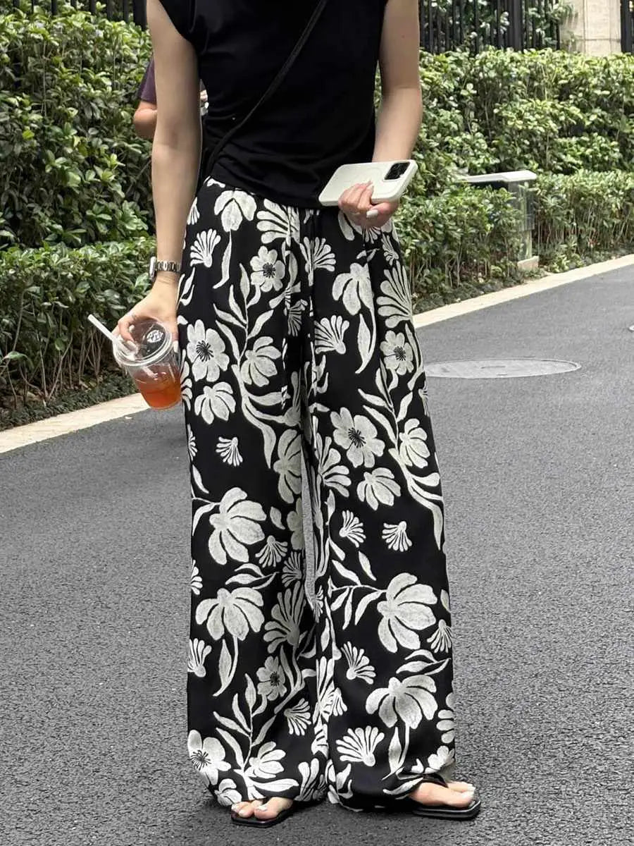 pantalons à jambes évasées et imprimé floral pour femmes, noir et blanc, avec un imprimé floral audacieux et une coupe à jambes évasées, idéal pour une tenue décontractée et stylée