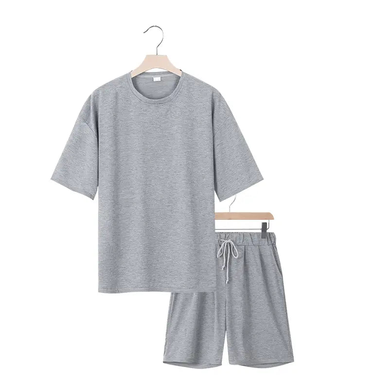 Conjunto veraniego de dos piezas para hombre, que presenta un conjunto de pijama de algodón gris jaspeado con parte superior de ajuste relajado y pantalones cortos con cordón para uso casual.