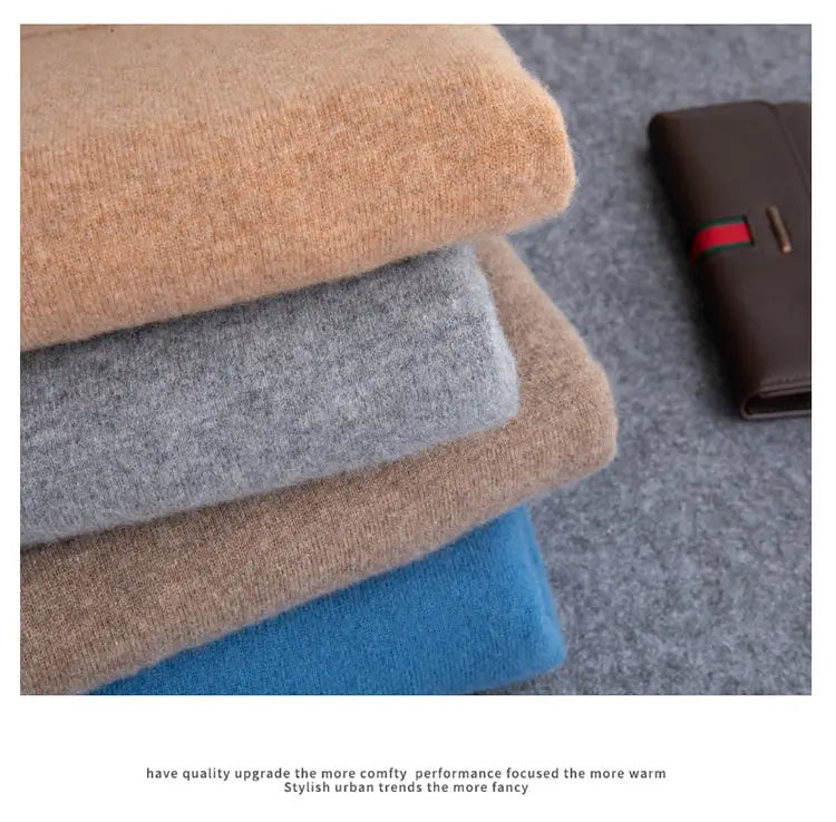 Stapeln Sie weiche gestrickte Herren-Merino-Cashmere-V-Ausschnitt-Pullover in den Tönen Camel, Grau und Blau.