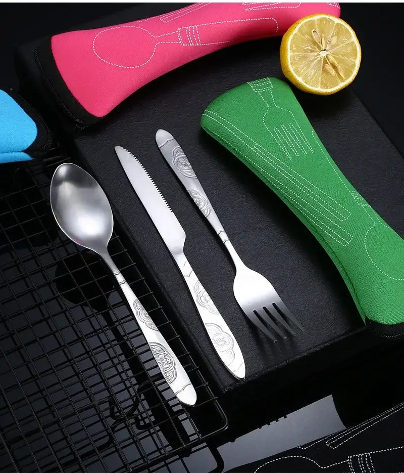 Silver stainless steel portable travel cutlery set with ornate floral patterned handles displayed alongside colorful fabric utensil cases.
