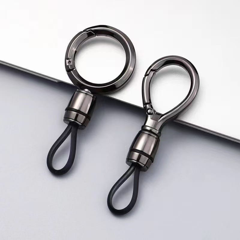 Dos anillos de mosquetón magnético de metal oscuro y elegante, con bucles de goma negra, diseñados como anillos de llaves anti-pérdida.
