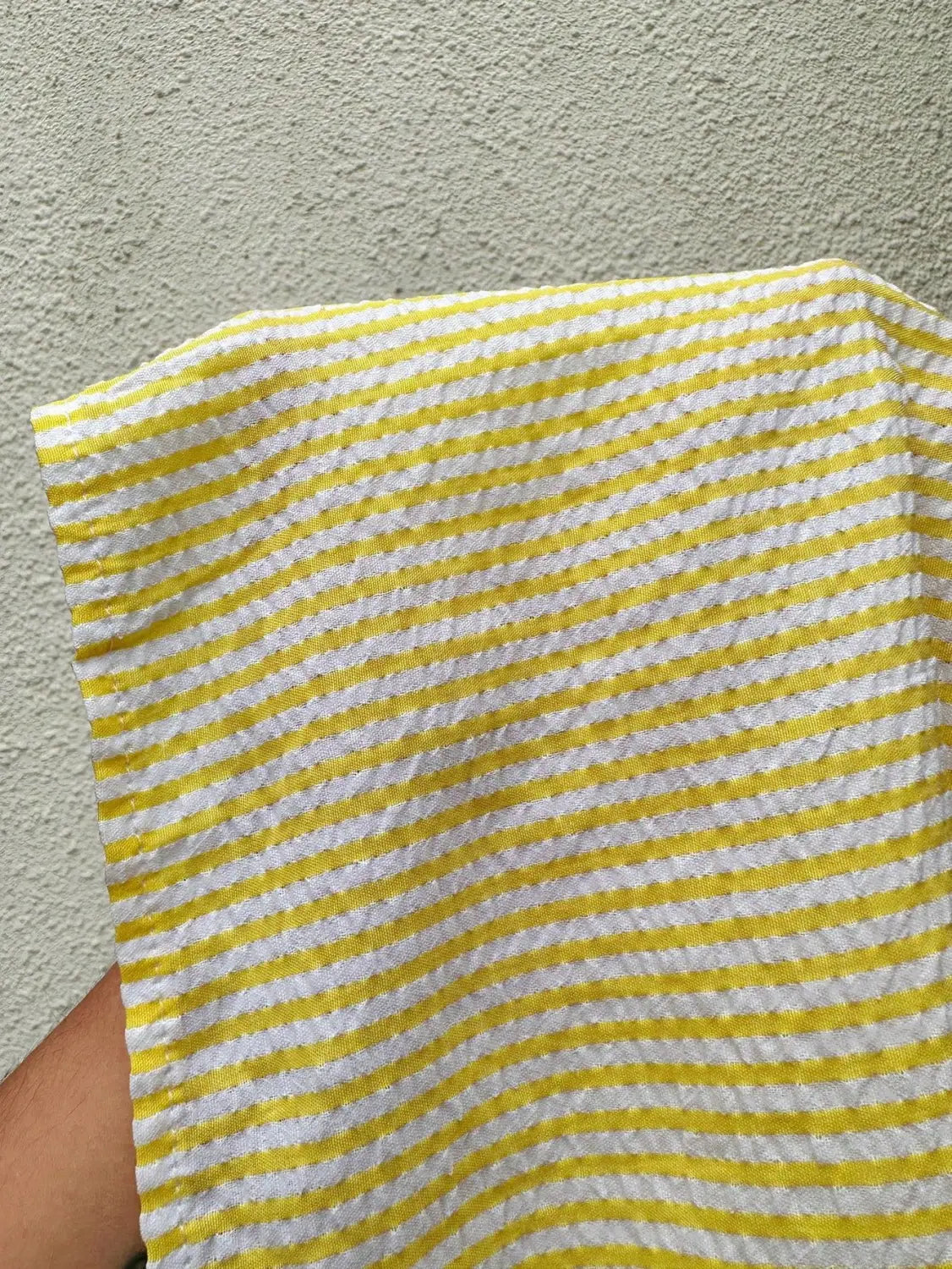 Maxi-jupe à volants rayés jaunes, assortie à un torchon de cuisine tissé à rayures jaunes et blanches.