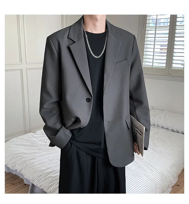 Ein eleganter dunkelgrauer Herren-Casual-Blazer mit modernem Schnitt und dezentem Strukturmuster.