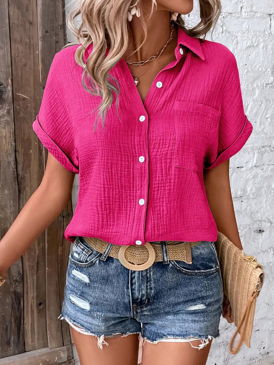 Vibrant pink women cotton short sleeve button up shirt with textured fabric and rolled cuffs.