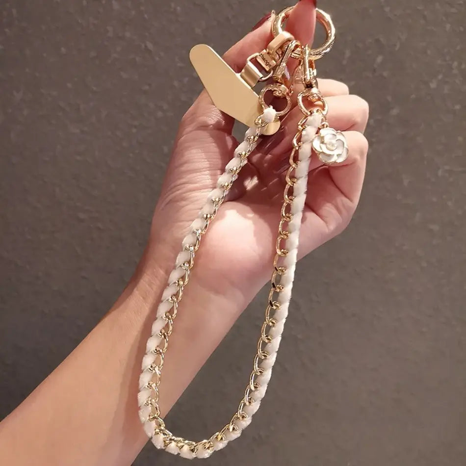 Handy-Handgelenkriemen aus goldfarbener Kette als Anti-Lost-Handylanyard, mit einer goldfarbenen Kette mit weißen Perlenakzenten und einem floralen Anhänger.