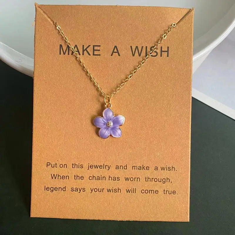 Un collier délicat en chaîne à maillons en or, avec un pendentif de fleur romantique et mignon : une fleur émaillée violette éclatante et un petit centre en pierre transparente.