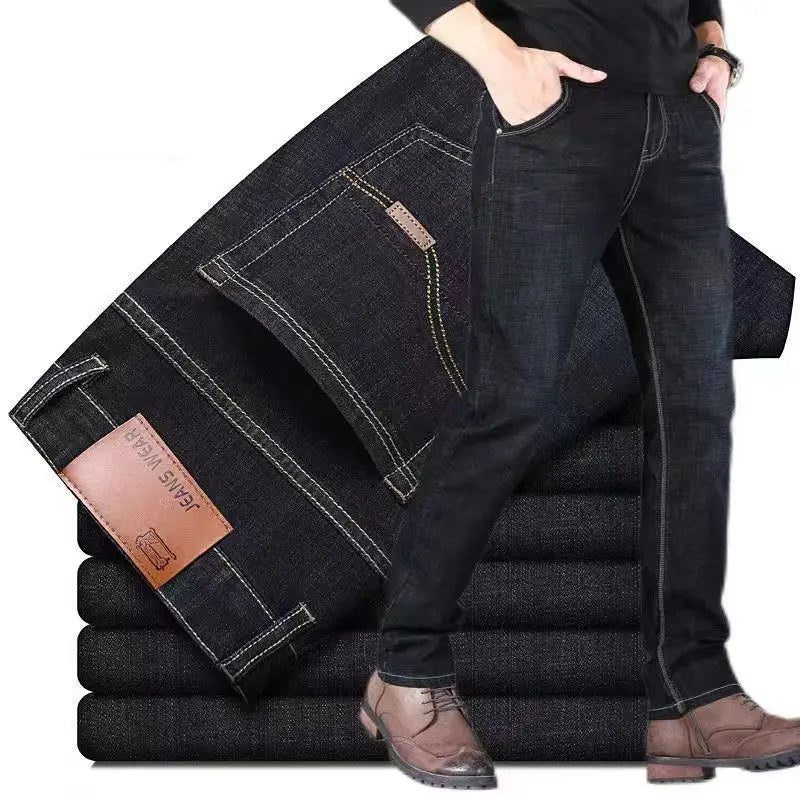Jeans stretch en denim à jambe droite pour homme en denim foncé, avec couture blanche et un écusson de marque en cuir brun.
