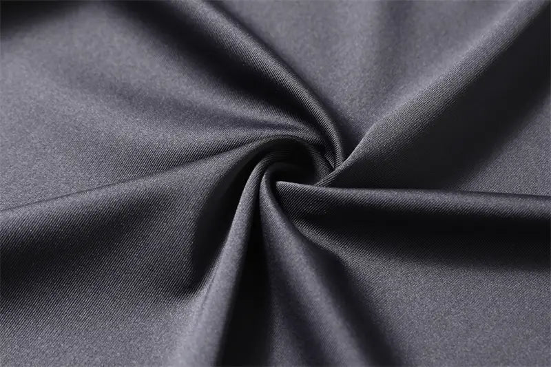 Camisa de vestir para hombre sin arrugas en tejido liso gris oscuro, con brillo sutil y patrón tejido fino.