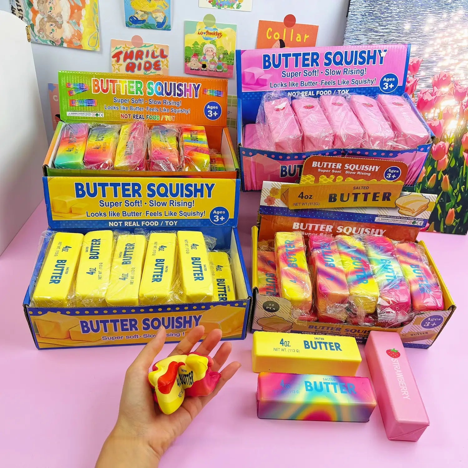 Une main tient un jouet antistress souple à la forme de beurre à la fraise, à montée lente, jaune et rouge, avec le mot « beurre » imprimé dessus.