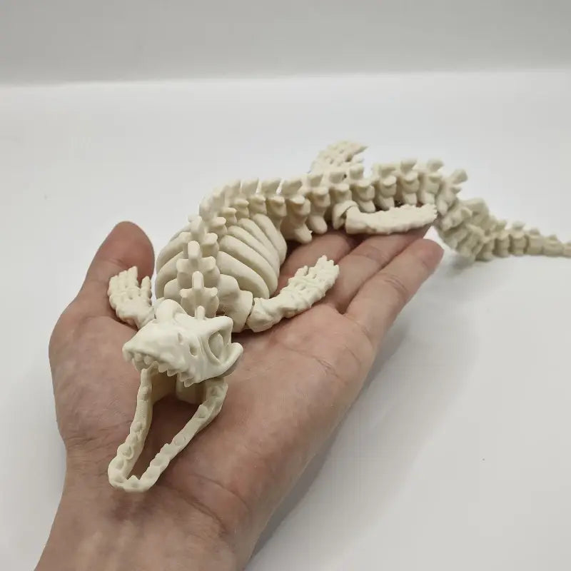 Un adorno para acuario de esqueleto de dinosaurio de resina 3D impreso, de color blanco marfil, con articulaciones articuladas y un diseño segmentado texturizado para simular paisajes acuáticos.