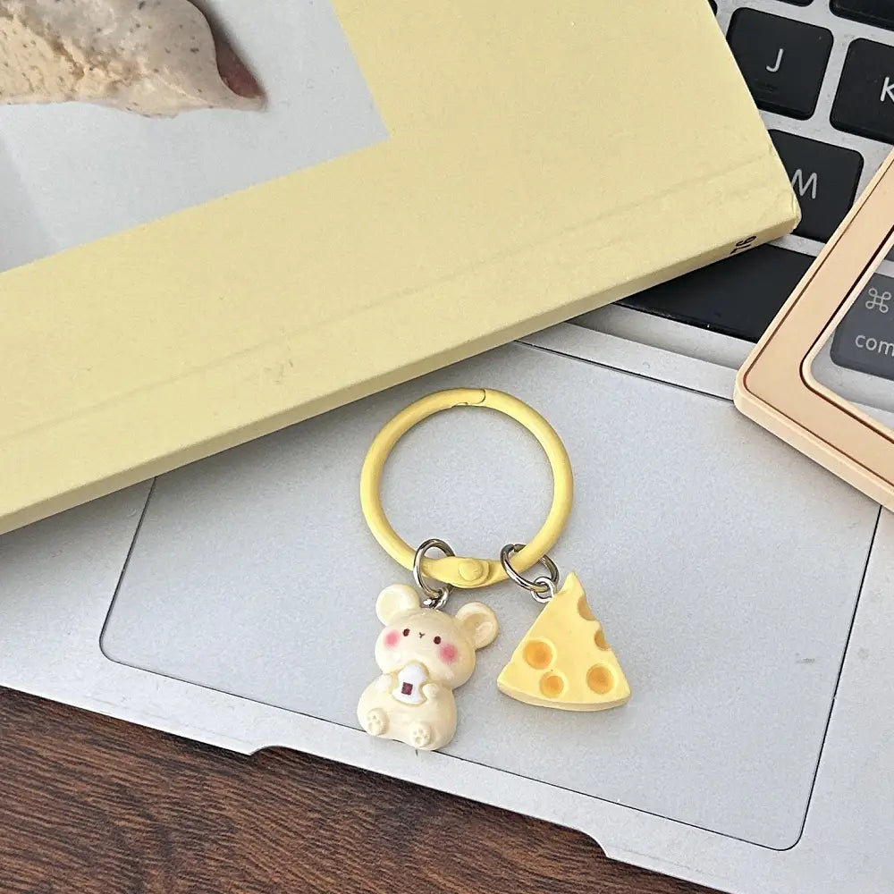 Yellow silicone keychain featuring a cute cream-colored mouse charm and a cheese slice pendant as a kawaii bag charm.