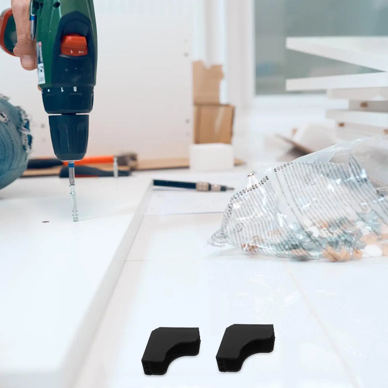 grüne und orange akkubetriebene Bohrmaschine ohne Kabel mit Metallspannfutter neben schwarzen Kunststoff-Eckschutzwinkeln zur Verwendung als Eckschoner in Anwendungen für den Heimschutz