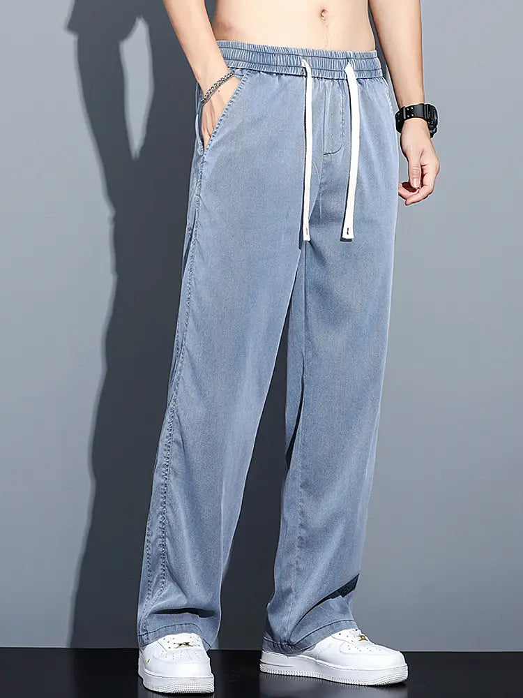 Men’s lyocell casual loose straight drawstring pants in light blue denim with white drawstrings and a relaxed straight-leg cut.
