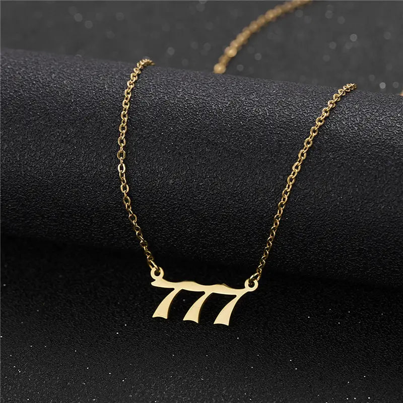 Gold angel number 7 necklace featuring a gold-colored delicate chain and a minimalist pendant shaped like the number 777.