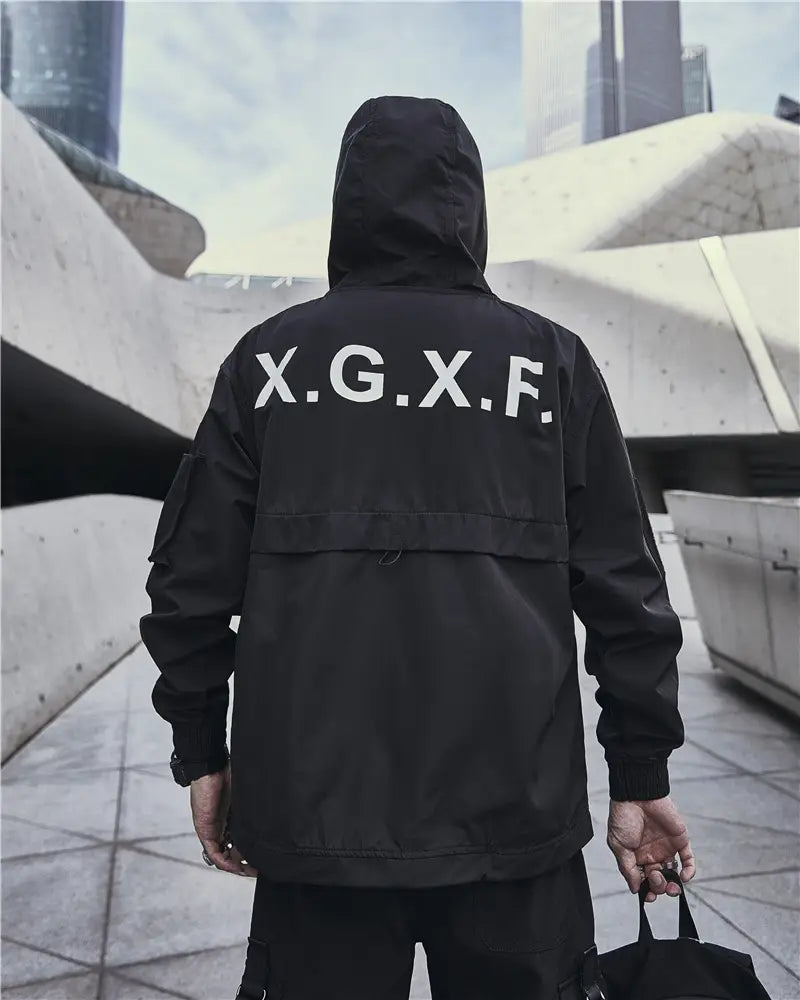 Veste tactique techwear imperméable à capuche noire, montrant la face arrière avec un lettrage x.g.x.f blanc en caractères gras sur toute la partie arrière