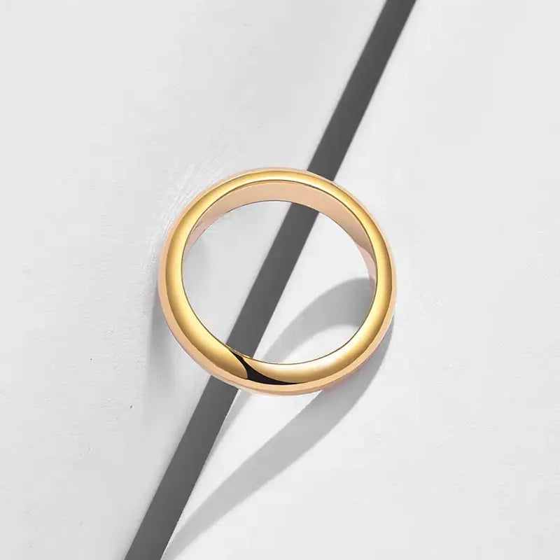 Un anillo de pareja de argollas de boda de oro de 18 quilates y 4 mm que presenta una banda pulida y elegante en color dorado, con un diseño liso y minimalista.