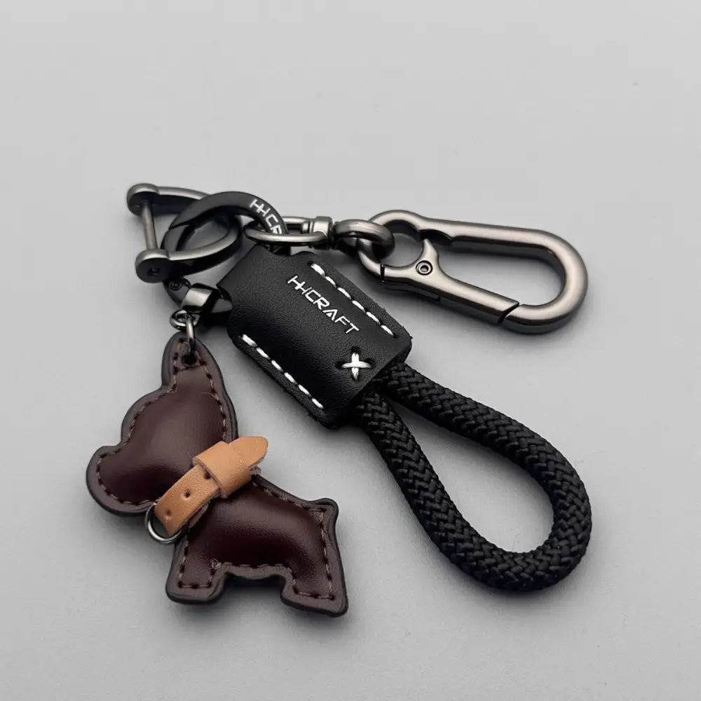 Black leather French bulldog keychain featuring a brown dog-shaped charm and braided black cord.
