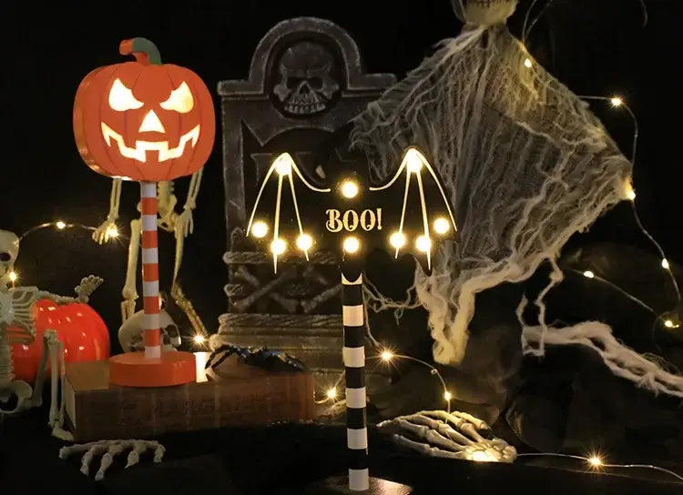 Eine leuchtende orangefarbene Halloween-LED-Nachtlicht-Dekoration mit geschnitztem Kürbisgesicht und einem gestreiften Stabfuß, ausgelegt für den Outdoor-Einsatz mit Wasserschutz