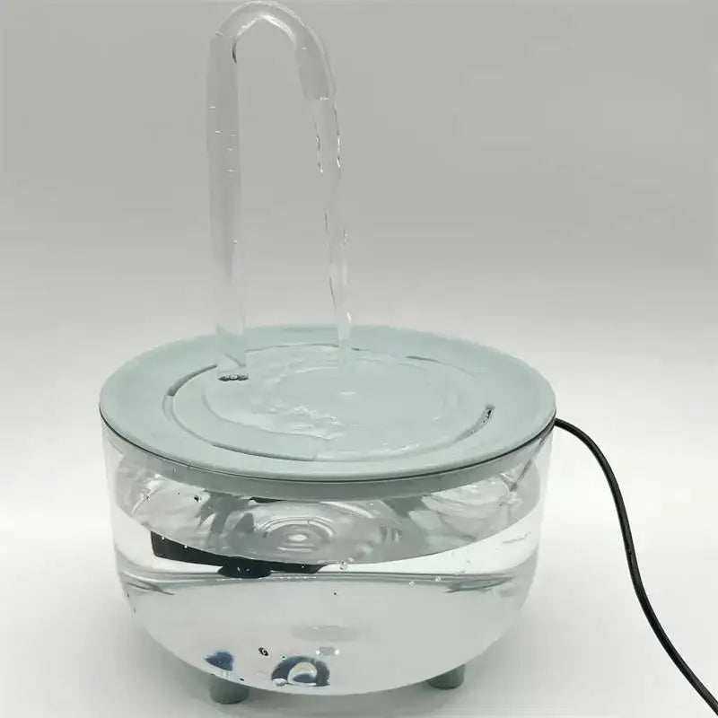 klarer Glas-Trinkwasserspender für Haustiere mit hellblauem Kunststoffoberteil und gebogenem Auslauf, mit integrierter Pumpe für kontinuierlichen Wasserfluss.