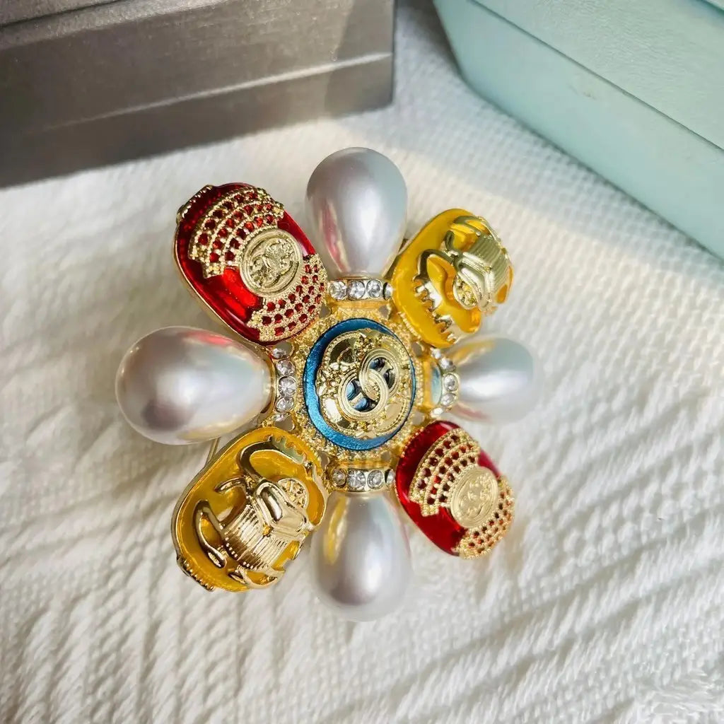 Broche de perles designer Chanel éclatante, en forme de fleur, avec des pétales d’émail rouge et or, des perles blanches et des cristaux de rhinestones scintillants.