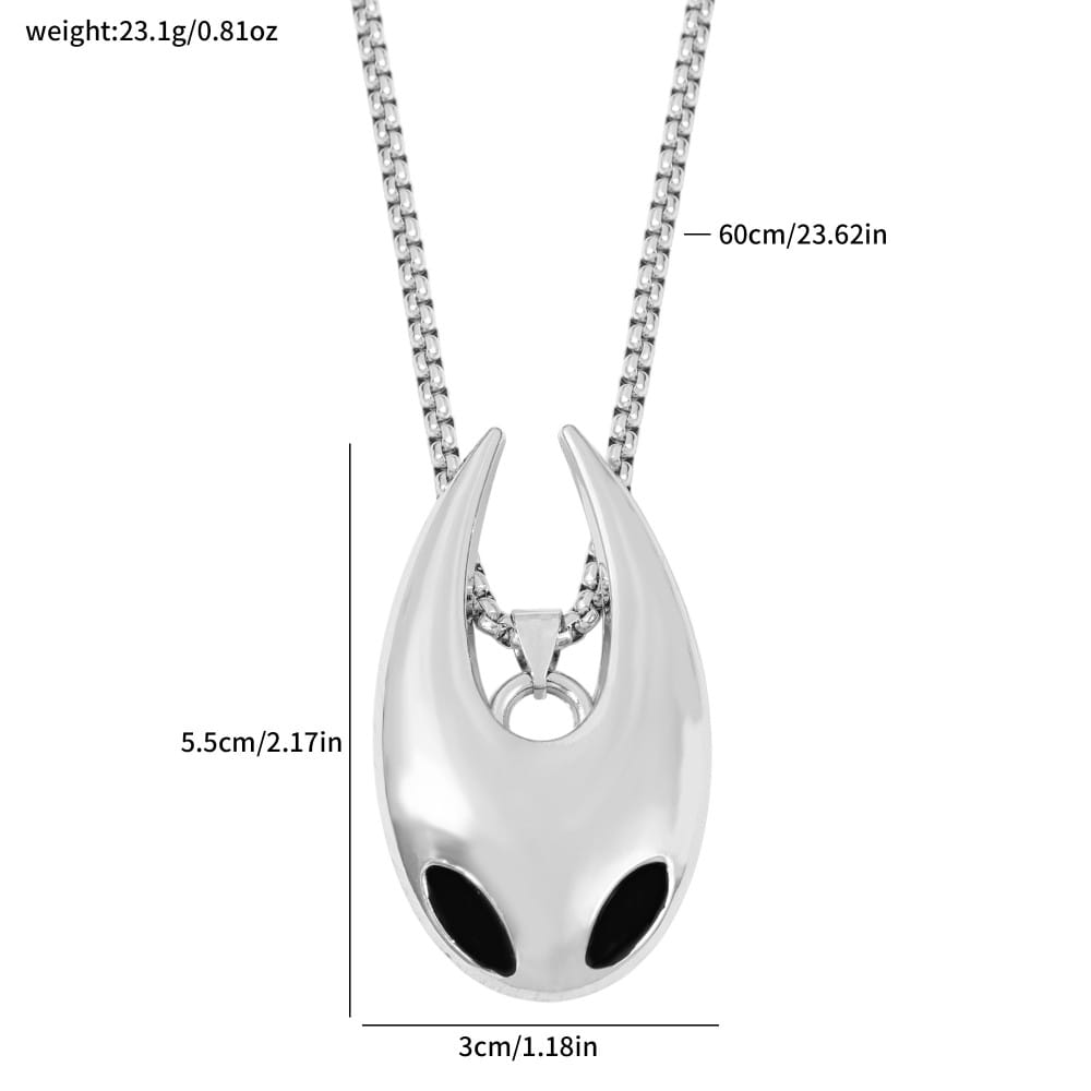 Pendentif argenté en forme d’alien avec des insertions d’yeux noirs, fabriqué en argent, suspendu à une chaîne assortie dans un collier de jeu en pendentif argenté de chevalier creux