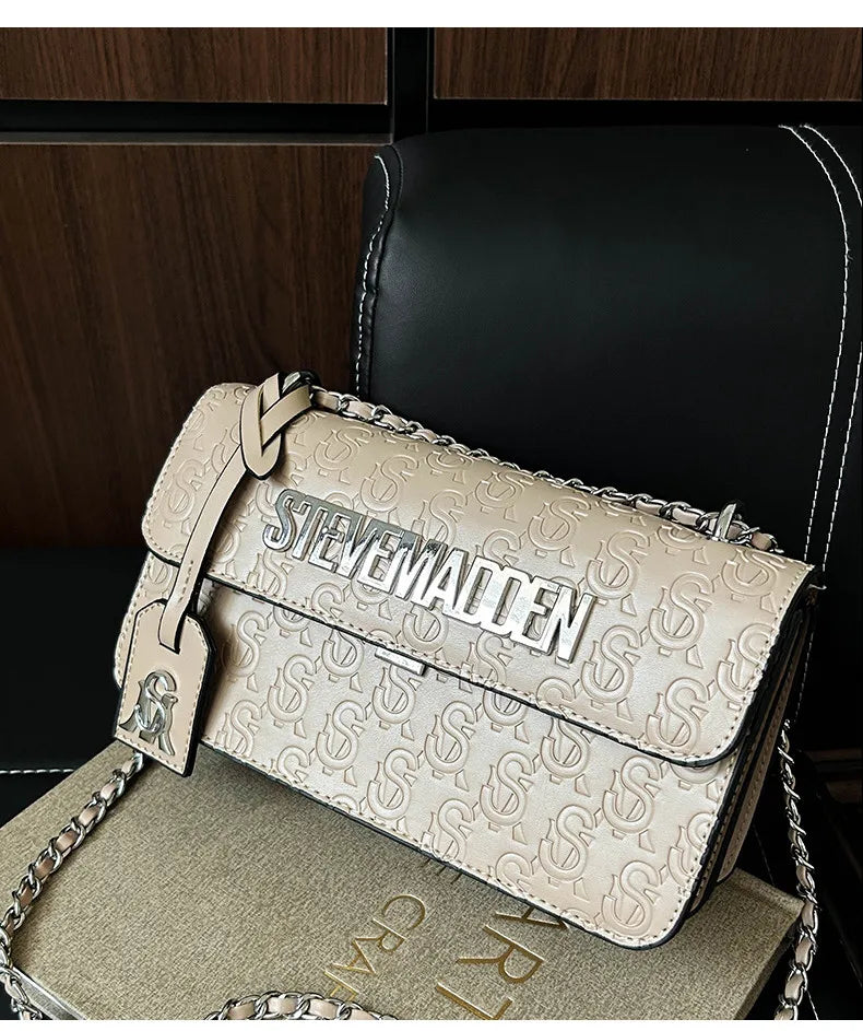 Elfenbeinfarbene Steve Madden gesteppte Umhängetasche aus Leder mit geprägtem Logo-Muster und Beschlägen in Silberoptik.