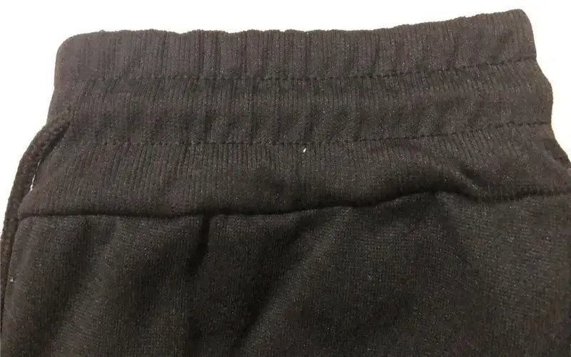 Schwarzer elastischer Bund mit gerippter Struktur und sichtbarer Ziernähte an Herren-Adidas-Sweatpants, Sport-Jogginghosen.