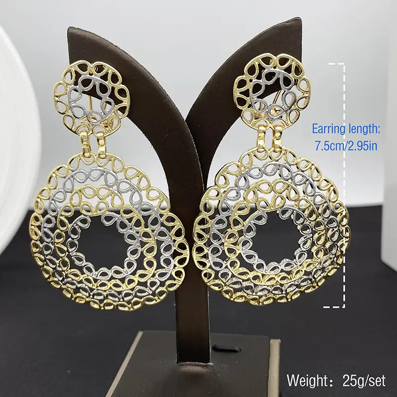 Boucles d’oreilles pendantes en filigrane bicolore or et argent, avec des motifs circulaires complexes de type dentelle, pour un ensemble de bijoux pour femmes.