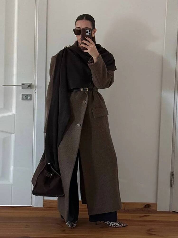 A dark brown wool blend structured trench coat with a belted waist and wide lapels designed as a women winter commuter jacket.