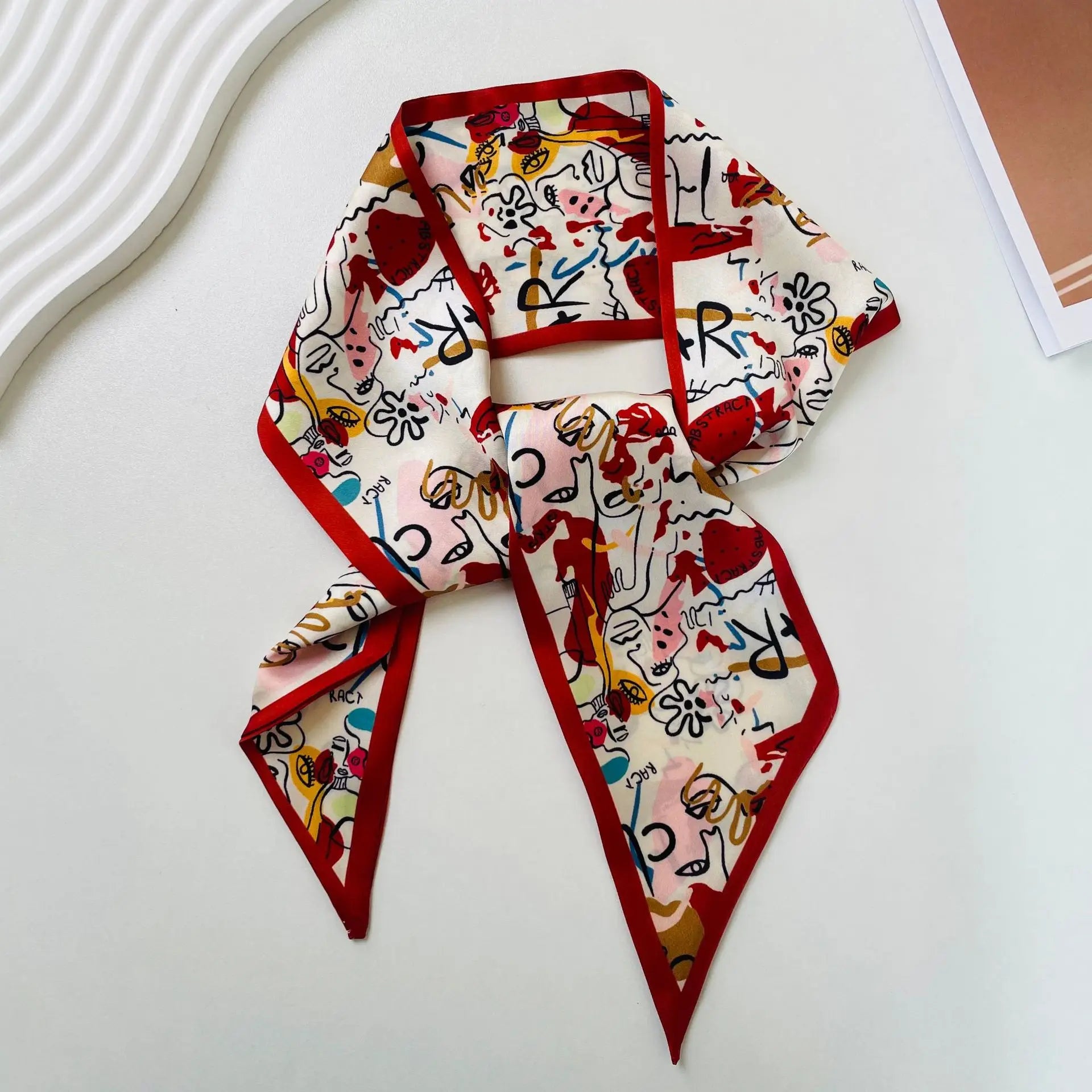 Pañuelo de seda vibrante color crema con un borde rojo intenso e ilustraciones abstractas juguetonas en negro, rojo, amarillo y azul, con diseño de estampado geométrico para banda de escote cuadrado.