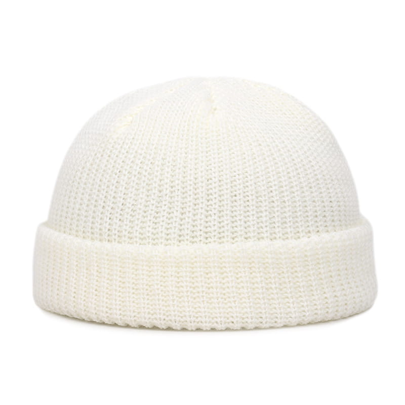 Cream-colored ribbed knit winter beanie hat with a folded brim made of warm knitted material for unisex use.